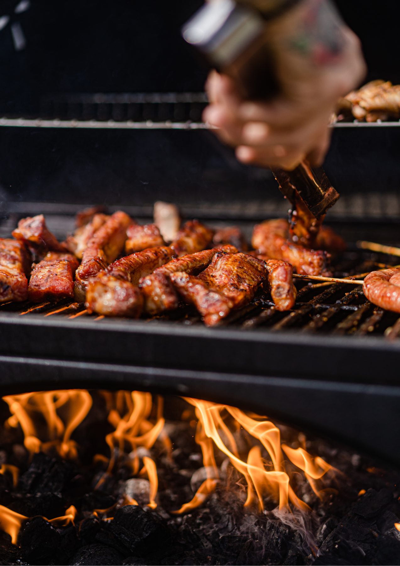 La griglia con le fiamme e la carne in cottura