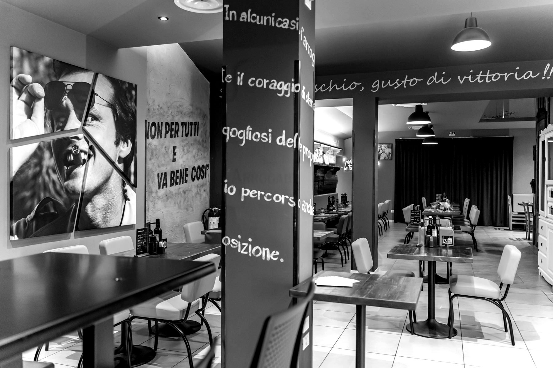 Il murale e i tavoli in legno della sala grande